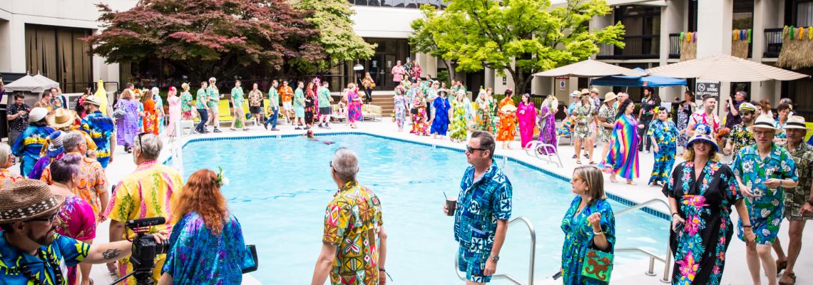 Colorfully dressed guests parade around the swimming pool at the Bananas for Cabanas and Crazy for Caftans meetup.